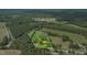 Aerial view of a rural property with a red brick home, enclosed by a fenced yard and surrounded by trees at 774 Salem Church Rd, Sanford, NC 27330