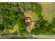 Aerial view of a fenced property featuring a red brick home, surrounded by lush greenery and mature trees at 774 Salem Church Rd, Sanford, NC 27330