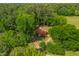 An aerial view of the cozy home nestled among lush trees, boasting a striking red roof and tranquil setting at 774 Salem Church Rd, Sanford, NC 27330