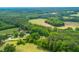 An aerial view of a property with a mix of lush green trees and cleared land, showcasing its natural beauty at 774 Salem Church Rd, Sanford, NC 27330