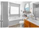Bright bathroom featuring a soaking tub, a window, and wood-look flooring at 1022 Early Rise St St, Raleigh, NC 27610