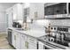 Modern kitchen featuring white cabinets, gold hardware, stainless steel appliances, and white subway tile backsplash at 1022 Early Rise St St, Raleigh, NC 27610