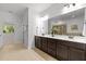 Bright bathroom features a double sink vanity, large mirror, and a view of the bath and shower at 109 Highland Mist Cir, Apex, NC 27539