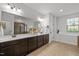 Bright bathroom featuring double vanity, large mirror, and a separate shower with tiled walls at 109 Highland Mist Cir, Apex, NC 27539