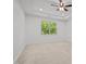 Bright bedroom with neutral carpet, tray ceiling, ceiling fan, recessed lights, and a large window at 109 Highland Mist Cir, Apex, NC 27539