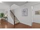 Bright entryway featuring hardwood floors, a staircase, and a modern art piece, creating a welcoming ambiance at 109 Highland Mist Cir, Apex, NC 27539