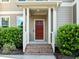 Covered front door features red door with green bushes on either side at 109 Highland Mist Cir, Apex, NC 27539