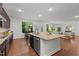 This open-concept kitchen features an island, stainless steel appliances, and views into the living and dining spaces at 109 Highland Mist Cir, Apex, NC 27539