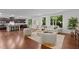 Inviting living room with hardwood floors, large windows and comfortable seating, seamlessly connected to an open-concept kitchen at 109 Highland Mist Cir, Apex, NC 27539