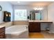 Bright bathroom featuring vanity, soaking tub, large mirror, and tile flooring at 112 Victorian Oaks Dr, Durham, NC 27713