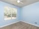 Empty bedroom features light blue walls, carpet, white trim, and a window with tree views at 112 Victorian Oaks Dr, Durham, NC 27713