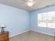 Neutral bedroom showcasing large window, blue walls, carpet, and ceiling fan at 112 Victorian Oaks Dr, Durham, NC 27713