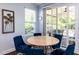 Bright dining area features a round table, blue chairs, and sliding glass doors to the outdoor patio at 112 Victorian Oaks Dr, Durham, NC 27713