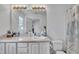 Bright bathroom features a large mirror, sink, toilet, and a shower with patterned curtains at 114 Montview Way, Knightdale, NC 27545