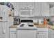 Kitchen featuring white cabinetry, laminate countertops, appliances, and hardwood flooring at 114 Montview Way, Knightdale, NC 27545