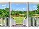Scenic backyard view of a lush landscape with a tranquil pond from the outdoor porch at 1199 Cesar Ct, Graham, NC 27253