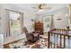 Bedroom filled with natural light, a cozy recliner, a classic crib, and cowboy decor for a charming space at 1199 Cesar Ct, Graham, NC 27253