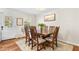 Bright dining room with a wood table, six chairs, area rug, and natural light from the large window at 1199 Cesar Ct, Graham, NC 27253