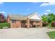Brick home featuring a covered porch, well-maintained lawn, and mature trees for a welcoming and serene setting at 1199 Cesar Ct, Graham, NC 27253