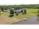 Beautiful view of the house exterior, featuring a pond with a dock and sprawling green lawn at 1199 Cesar Ct, Graham, NC 27253
