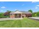 Brick home with a covered porch, spacious yard, and mature landscaping provides a welcoming and picturesque setting at 1199 Cesar Ct, Graham, NC 27253