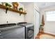 Convenient laundry room with modern washer and dryer, storage shelves, and hardwood floors at 1199 Cesar Ct, Graham, NC 27253