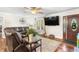 Inviting living room featuring a leather sectional, wood floors, and a large TV at 1199 Cesar Ct, Graham, NC 27253
