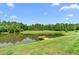 Scenic view of the pond with a dock and canoe, nestled within a private, wooded setting at 1199 Cesar Ct, Graham, NC 27253