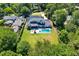 Aerial view of a home with a lush backyard, modern pool, and expansive lawn surrounded by mature trees at 1209 Briar Patch Ln, Raleigh, NC 27615