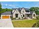 Beautiful two-story home with a manicured lawn and a three-car garage in daytime at 1209 Briar Patch Ln, Raleigh, NC 27615