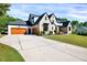 Exterior of a two-story home with an extra-long driveway, two garage doors, and manicured lawn at 1209 Briar Patch Ln, Raleigh, NC 27615