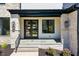 Close-up view of a home's front entry with stone trim, black accents, and well-kept landscaping at 1209 Briar Patch Ln, Raleigh, NC 27615