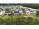 Aerial view showcasing houses within a residential area surrounded by lush green trees at 126 Thimbleweed Ln, Lillington, NC 27546