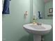 This powder room features a pedestal sink, stylish light fixture, and calming green walls at 126 Thimbleweed Ln, Lillington, NC 27546