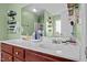 This bathroom features double sinks, wood cabinets, storage shelves, and shower at 126 Thimbleweed Ln, Lillington, NC 27546