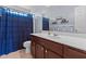 This bathroom features a shower with blue curtain, vanity and mirror, and toilet at 126 Thimbleweed Ln, Lillington, NC 27546