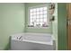 Relax in this tub with natural light from window, and convenient shelf storage at 126 Thimbleweed Ln, Lillington, NC 27546
