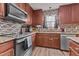 Well-lit kitchen features stainless steel appliances, granite countertops, mosaic backsplash and wood cabinets at 126 Thimbleweed Ln, Lillington, NC 27546