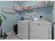 Functional laundry room with washer, dryer, shelving, and ample space for laundry tasks at 126 Thimbleweed Ln, Lillington, NC 27546