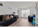 Bright living room featuring dark sofas, a window, and wood-look floors at 126 Thimbleweed Ln, Lillington, NC 27546