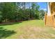 Well-maintained backyard with a large lawn, mature trees, and access to a wooden deck at 1301 Doylin Dr, Cary, NC 27511