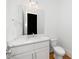 Stylish powder room with marble countertop, modern fixtures, and white cabinetry at 1301 Doylin Dr, Cary, NC 27511