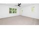 Spacious bedroom with neutral carpet, ceiling fan, and a large window letting in natural light at 1301 Doylin Dr, Cary, NC 27511