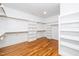 Walk-in closet with hardwood floors and custom shelves at 1301 Doylin Dr, Cary, NC 27511