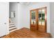 The foyer is full of light and features double glass doors, wood floors and stairway at 1301 Doylin Dr, Cary, NC 27511