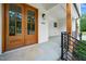 Close-up of the elegant wood double doors and covered porch with sleek design and a modern aesthetic at 1301 Doylin Dr, Cary, NC 27511