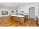 Kitchen island with marble countertops, pendant lighting, stainless faucet, and hardwood floors at 1301 Doylin Dr, Cary, NC 27511