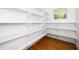 Spacious pantry with custom shelving, hardwood floors, and a window at 1301 Doylin Dr, Cary, NC 27511