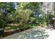 Large partially shaded backyard with a wooden deck and mature landscaping at 1324 Swallow Dr, Raleigh, NC 27606