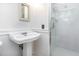 A pedestal sink is complemented by a glass shower in this bright, white bathroom at 1324 Swallow Dr, Raleigh, NC 27606